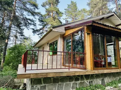a tiny house with a wrap around porch at Вила Данели in Tsigov Chark