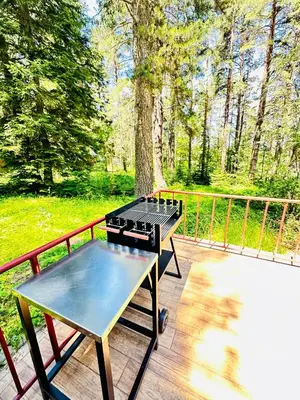 a grill on a deck next to a fence at Вила Данели in Tsigov Chark