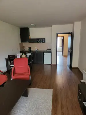 a living room with a red couch and a kitchen at Bansko Royal towers Ski Lift Area in Bansko