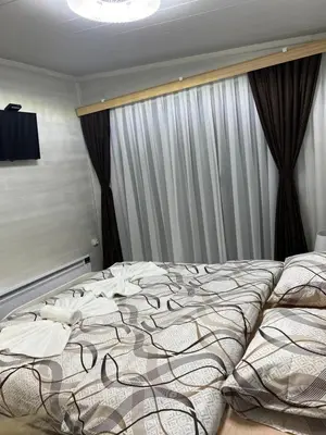 a bedroom with a large bed in front of a window at SAFI FOREST village in Dospat
