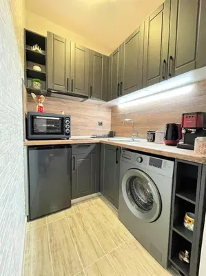 a kitchen with a washing machine and a microwave at Apartment in the Top center next to NDK in Sofia