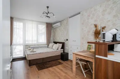 a bedroom with a bed and a desk and a window at Vitosha Boulevard Studio in Sofia