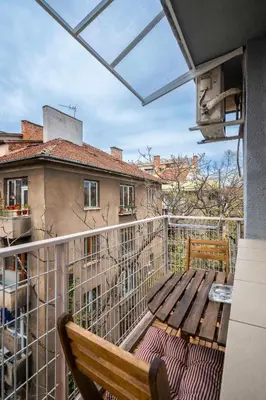 a balcony with a wooden table and a bench at Vitosha Boulevard Studio in Sofia