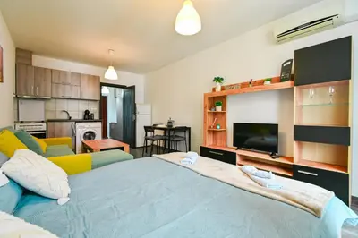 a bedroom with a large blue bed and a kitchen at Studio 19 in Sofia