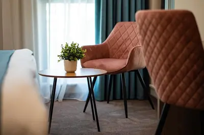 a room with a chair and a table with a plant at Aurora Sofia in Sofia