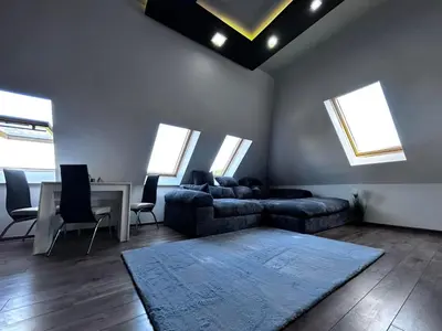 a living room with a couch and a table and windows at кристален въздух in Sofia