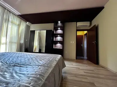 a bedroom with a bed and a large window at кристален въздух in Sofia