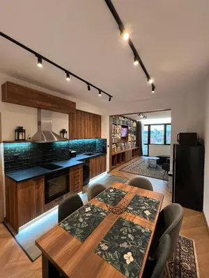 a kitchen with a wooden table and some chairs at Home Library in Sofia
