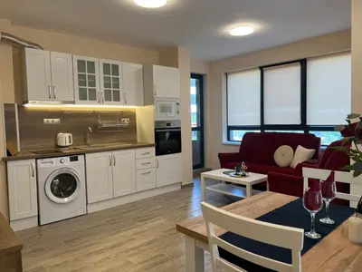 a kitchen and living room with a couch and a table at Cherry Apartment with 2 bedrooms in Sofia