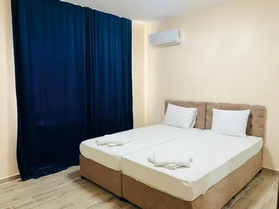 a bedroom with a bed with a blue curtain at Cherry Apartment with 2 bedrooms in Sofia