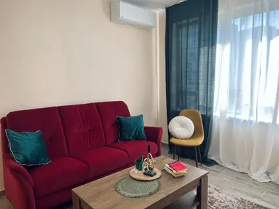 a living room with a red couch and a coffee table at Strаwberry Apartment in Sofia