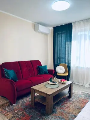 a living room with a red couch and a coffee table at Strаwberry Apartment in Sofia