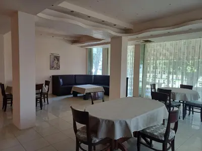 a dining room with tables and chairs and a couch at Интернационал in Kulata
