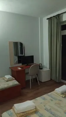 a bedroom with a desk with a computer and a chair at Интернационал in Kulata