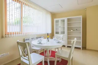 a dining room with a white table and chairs at Bright 1BDR Apartment in Top Center in Sofia