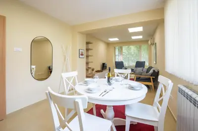 a white dining room with a white table and chairs at Bright 1BDR Apartment in Top Center in Sofia