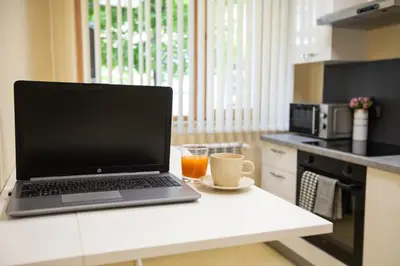a laptop computer sitting on a counter in a kitchen at Bright 1BDR Apartment in Top Center in Sofia