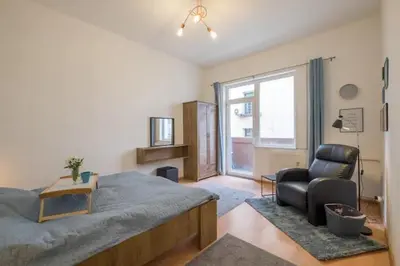 a bedroom with a bed and a chair and a window at Stay and Play - Foosball and Comfort in Sofia