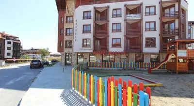 a building with a playground in front of a building at Predela 1 Bansko Apartment in Bansko