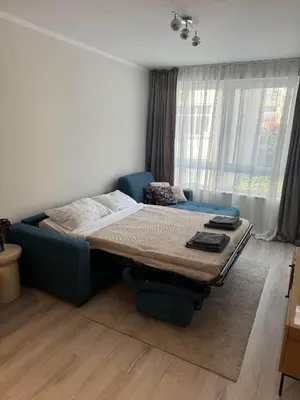 a bed in a room with a large window at Lux City Apartment, free parking in Pazardzhik