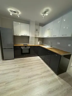 a kitchen with white cabinets and a wooden counter top at Lux City Apartment, free parking in Pazardzhik