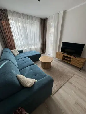 a living room with a blue couch and a television at Lux City Apartment, free parking in Pazardzhik