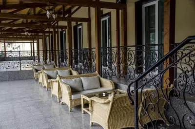 a row of wicker chairs on a balcony at Rubis Hotel in Rudozem