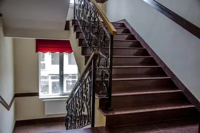 a staircase with a wrought iron railing and a window at Rubis Hotel in Rudozem