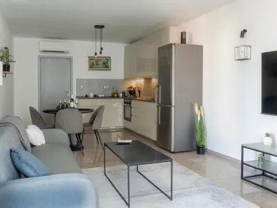 a living room with a couch and a table and a refrigerator at Vertigo 2 Modern 2-Bedroom Apartment with Parking & Vitosha View in Sofia