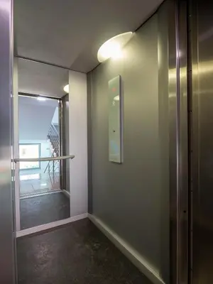 a hallway with a glass door and a window at Vertigo 2 Modern 2-Bedroom Apartment with Parking & Vitosha View in Sofia