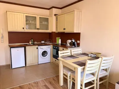 a kitchen with a table and a dishwasher at Apartment Saint Ivan Ski Resort in Bansko