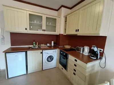 a kitchen with white cabinets and a washing machine at Apartment Saint Ivan Ski Resort in Bansko