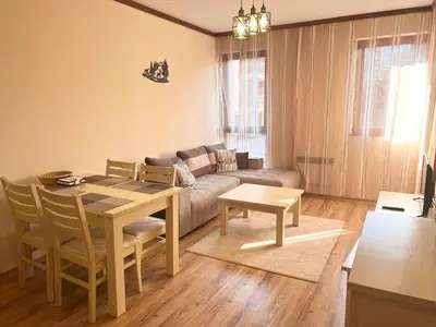 a living room with a table and a couch at Apartment Saint Ivan Ski Resort in Bansko