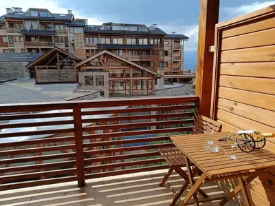 a balcony with a table and a view of a building at Apartment Saint Ivan Ski Resort in Bansko