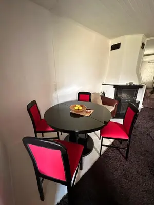 a dining room with a table and red chairs at Lea Hause with swimming pool,Jacuzzi in Vitosha montain and free parking in Sofia
