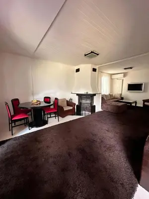 a living room with a couch and a table with chairs at Lea Hause with swimming pool,Jacuzzi in Vitosha montain and free parking in Sofia