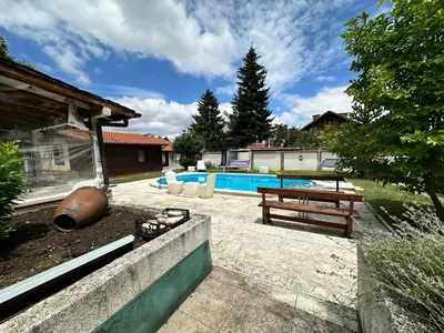 a backyard with a pool and a picnic table at Lea Hause with swimming pool,Jacuzzi in Vitosha montain and free parking in Sofia
