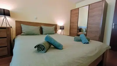 a bedroom with a large bed with blue pillows on it at Kandahar Private Apartments in Bansko