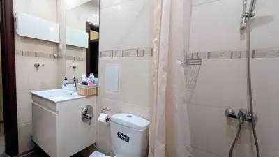 a bathroom with a toilet and a shower and a sink at Kandahar Private Apartments in Bansko