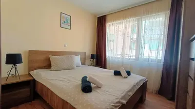 a bedroom with a bed with two slippers on it at Kandahar Private Apartments in Bansko