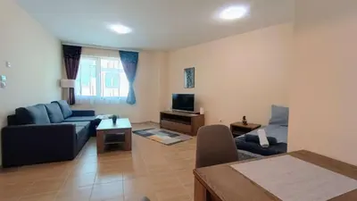 a living room with a couch and a tv at Kandahar Private Apartments in Bansko