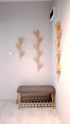 a bench against a white wall with wooden shelves at Cozy Boho small apartment in Sofia