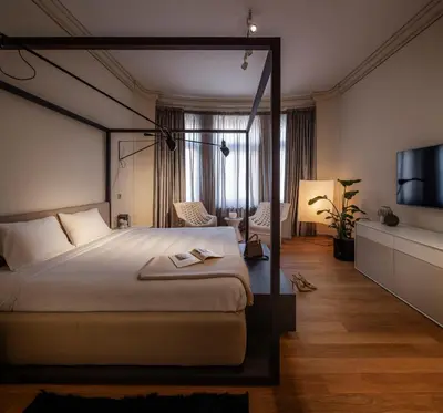 a bedroom with a canopy bed and a television at The Nest by Juno Hotel Sofia in Sofia