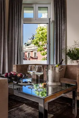 a living room with a table and a window at The Nest by Juno Hotel Sofia in Sofia