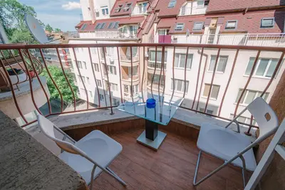 a balcony with chairs and a glass table and a building at Sofia Centre with Free on-site Parking in Sofia