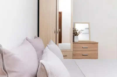 a bedroom with a mirror and a bed with pillows at Black Peak Panorama central apartment in Sofia