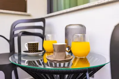 two glasses of orange juice on a glass table at Happy People Plovdiv - Grey 1-BD Apartment by Flat Mаnager in Plovdiv