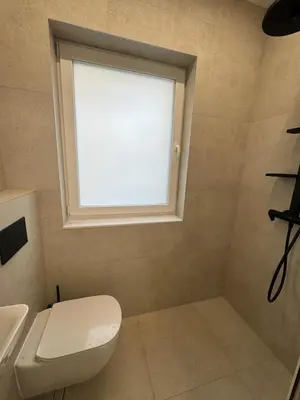 a bathroom with a toilet and a window at Luxurious House with Deluxe rooms & Free Secured Parking in Sofia