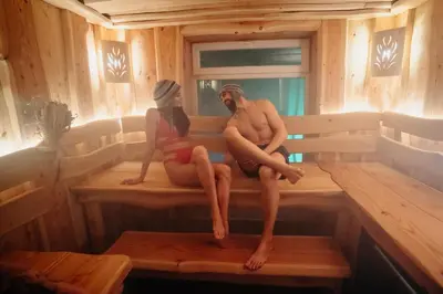 a man and a woman sitting on a bench in a sauna at Вила Княжеска баня in Sofia