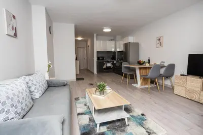 a living room with a couch and a table at Cozy 1BR in Heart of Oborishte with Private Parking in Sofia